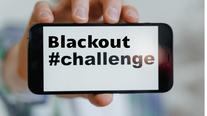 Ein junger Mensch, der Handy mit #Blackout-Challenge Schriftzug in der Hand h&auml;lt