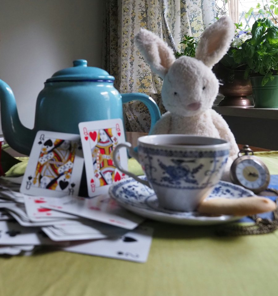 Paola Munzi (@alicecheshire) auf unsplash Hase mit Kaffeetasse und Kartenspiel